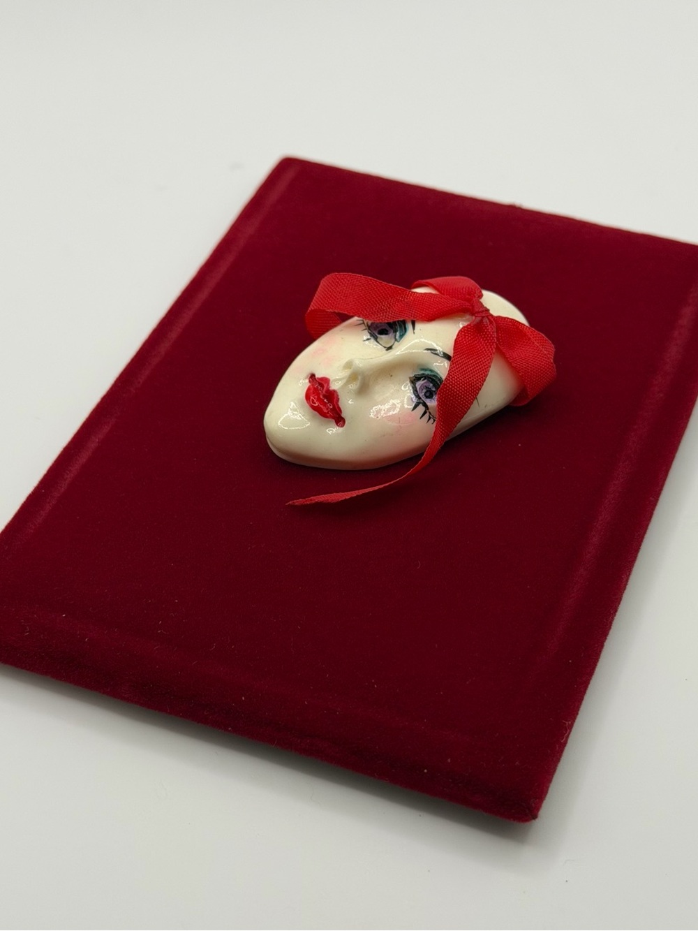 Vintage Face Brooch with Red Ribbon Accent